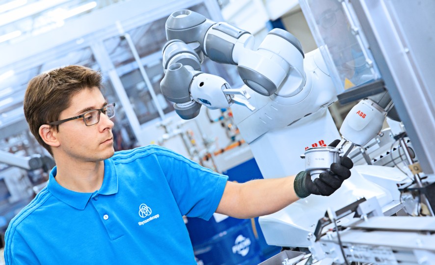 thyssenkrupp Mitarbeiter mit kollaborativem Roboter Yumii in der Lenkungsproduktion thyssenkrupp Mitarbeiter mit kollaborativem Roboter Yumii in der Lenkungsproduktion