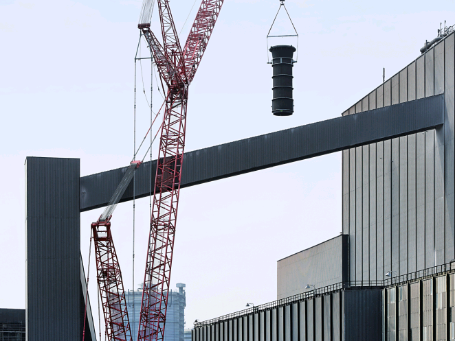 Von außen sieht man, wie die neuen Kesselsysteme zum Dach des Stahlwerks geschwenkt werden.