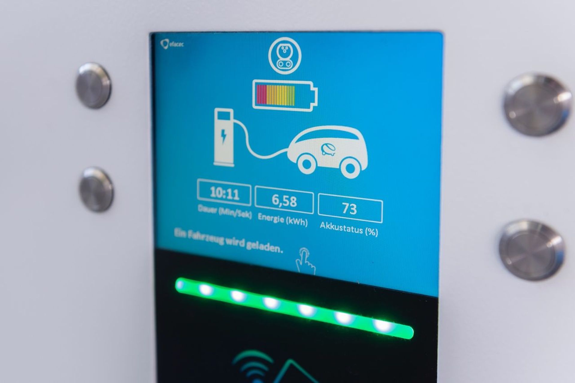 A charging station's display shows an electric car charging with a battery level of 73 percent.