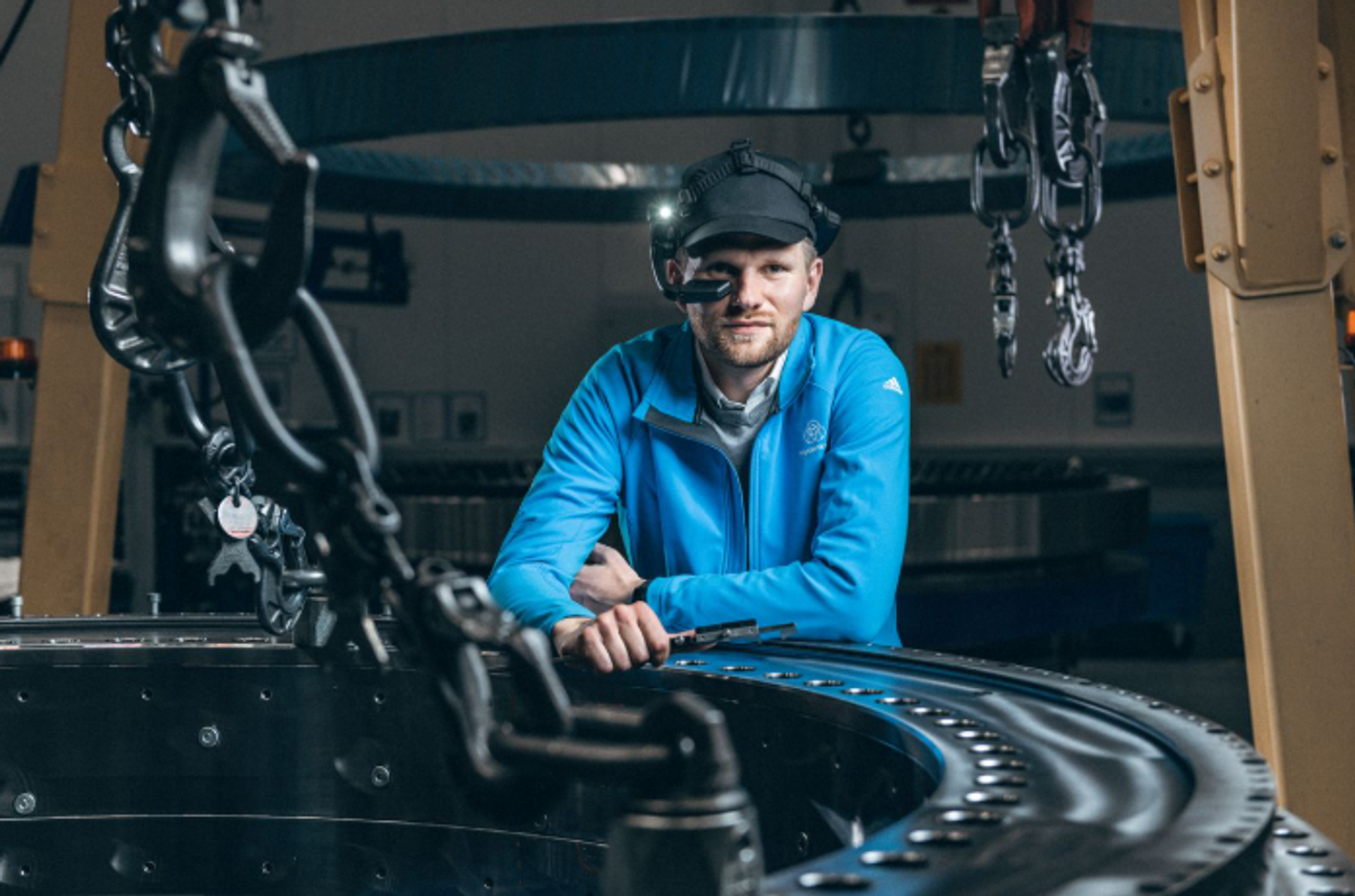 Mitarbeiter von thyssenkrupp rothe erde nutzt Smart Glasses bei der Qualitätsprüfung eines Großwälzlagers in der Produktion.