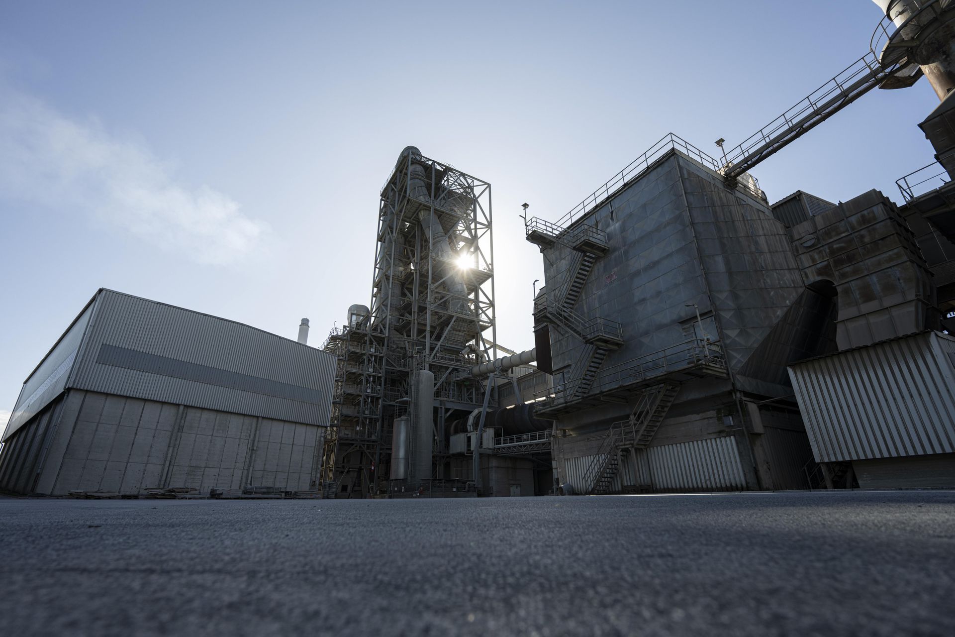 Industrieanlage in einem Zementwerk mit Produktionsgebäuden und Ofenturm für die Klinkerherstellung.