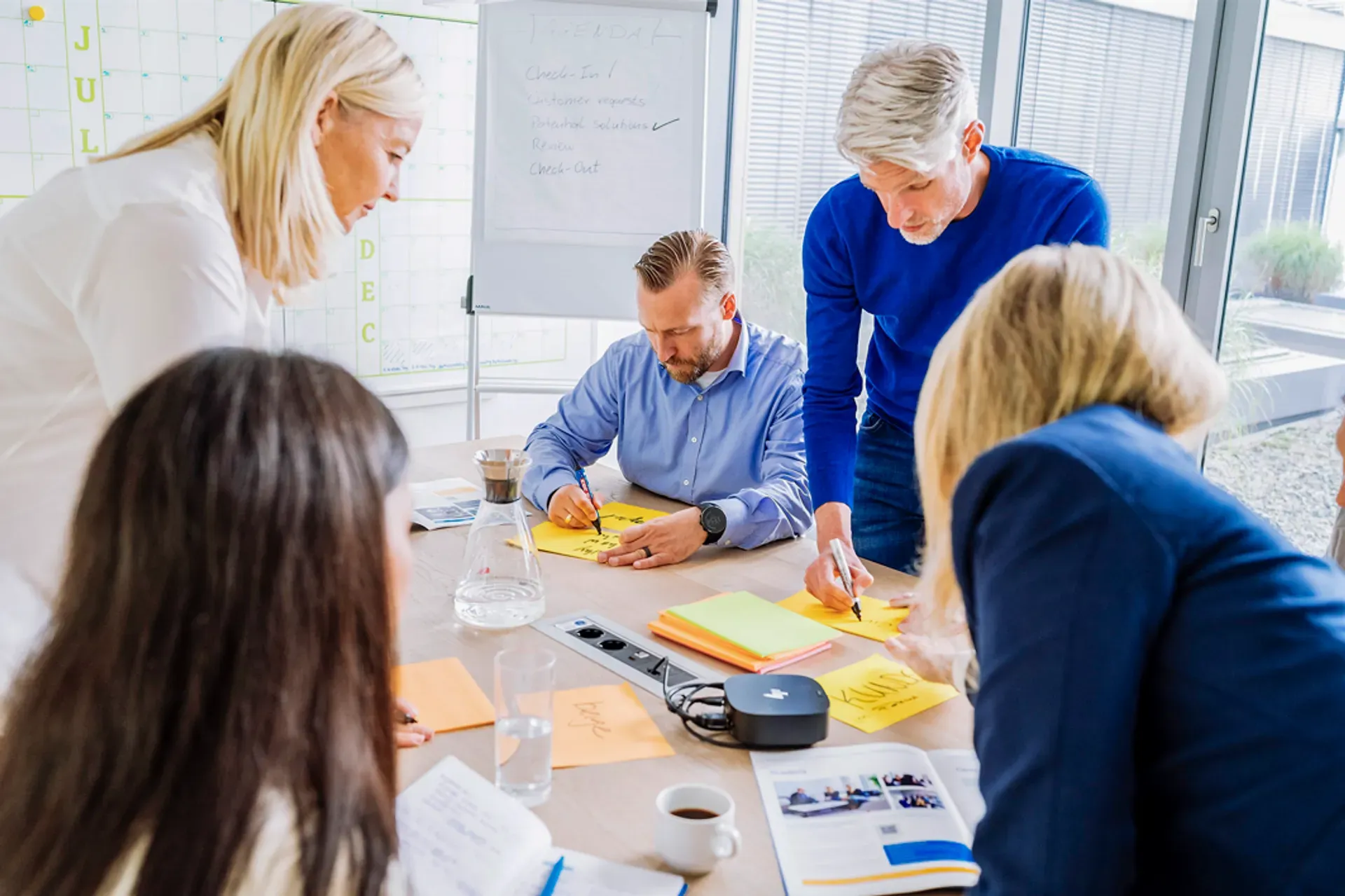 thyssenkrupp professional development – employees working together at a production or lab table, collaborating hands-on on a shared task