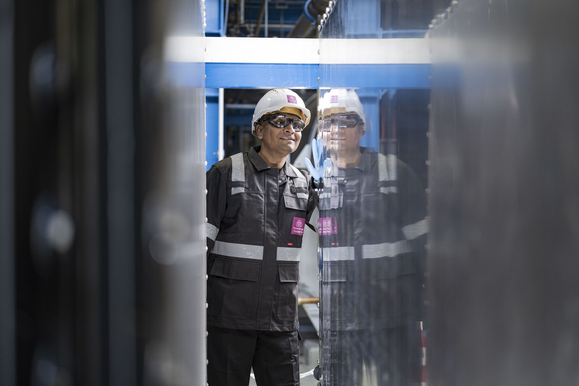 An employee of thyssenkrupp nucera inspects an electrolyzer cell at a production facility.