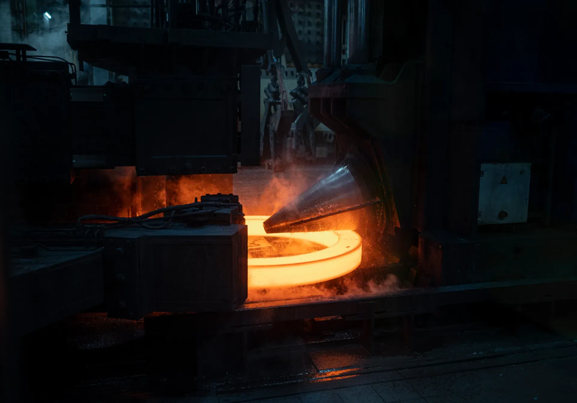 Ein glühender Ring wird bei thyssenkrupp rothe erde präzise in Form gebracht.