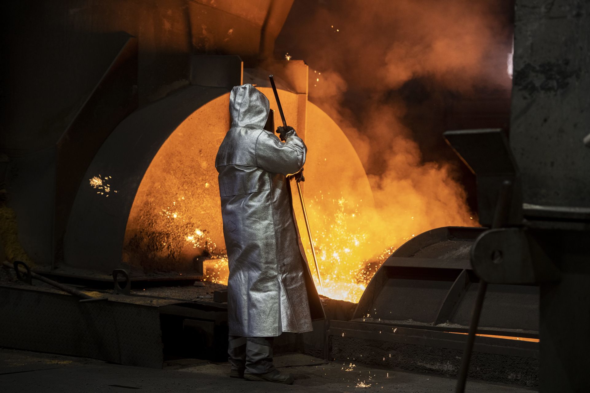 Mitarbeiter von thyssenkrupp Steel in Schutzkleidung bei Arbeiten an einem Hochofen in der Stahlproduktion.