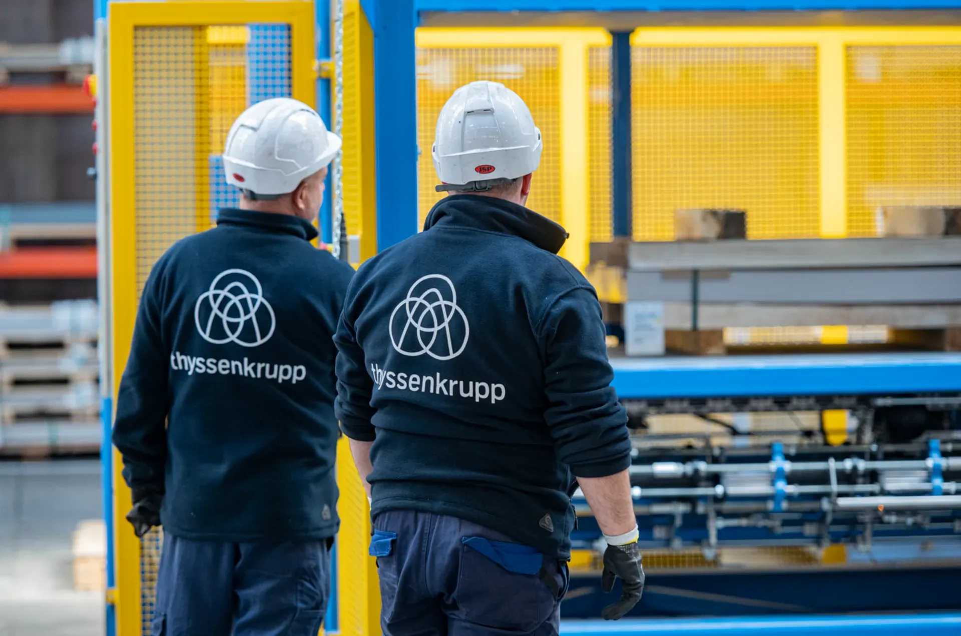 thyssenkrupp employees walking through an industrial facility representing human rights, responsibility and ethical workplace values