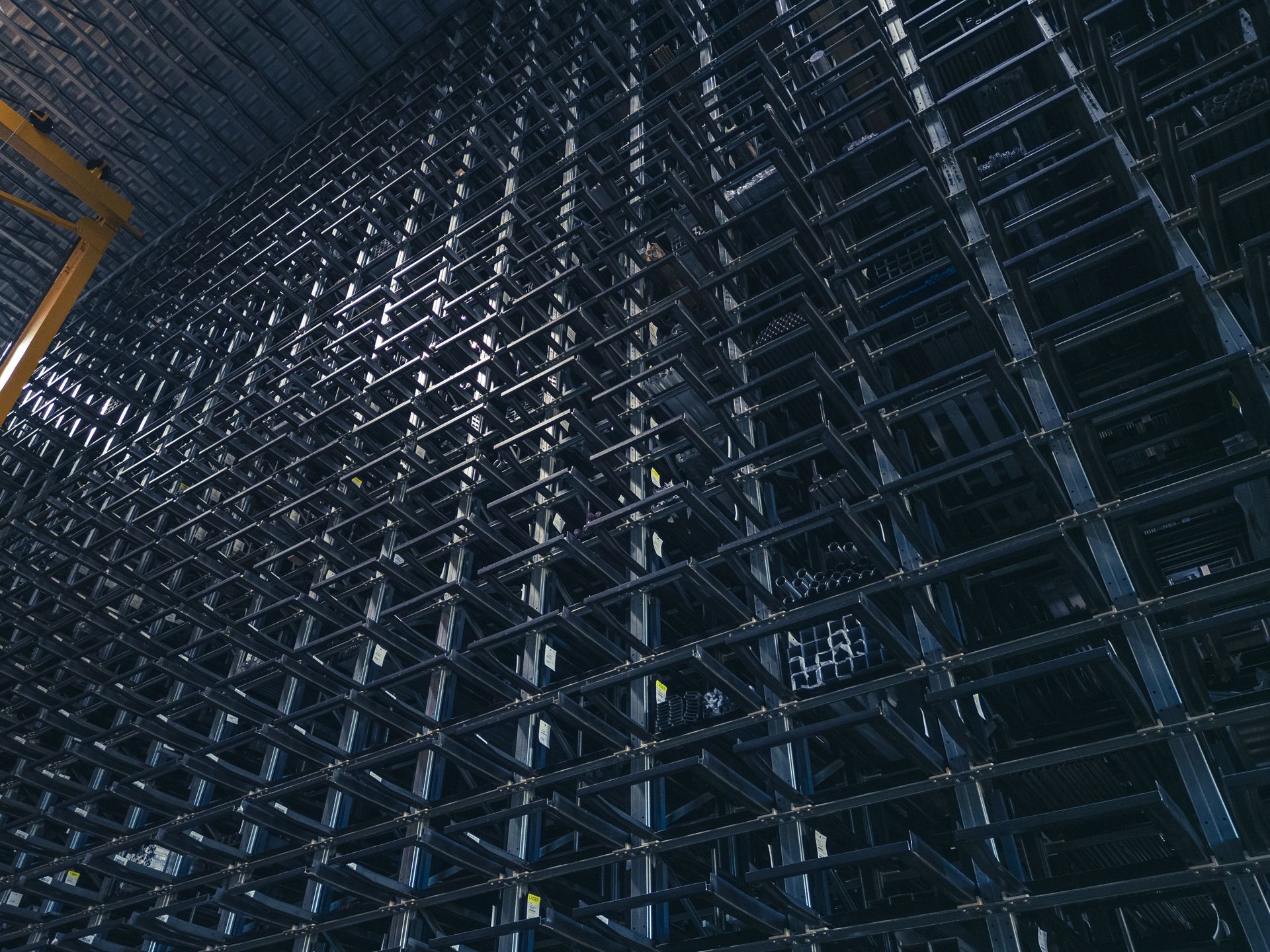 A view inside a large-scale high-bay warehouse with numerous storage bays for metal products.