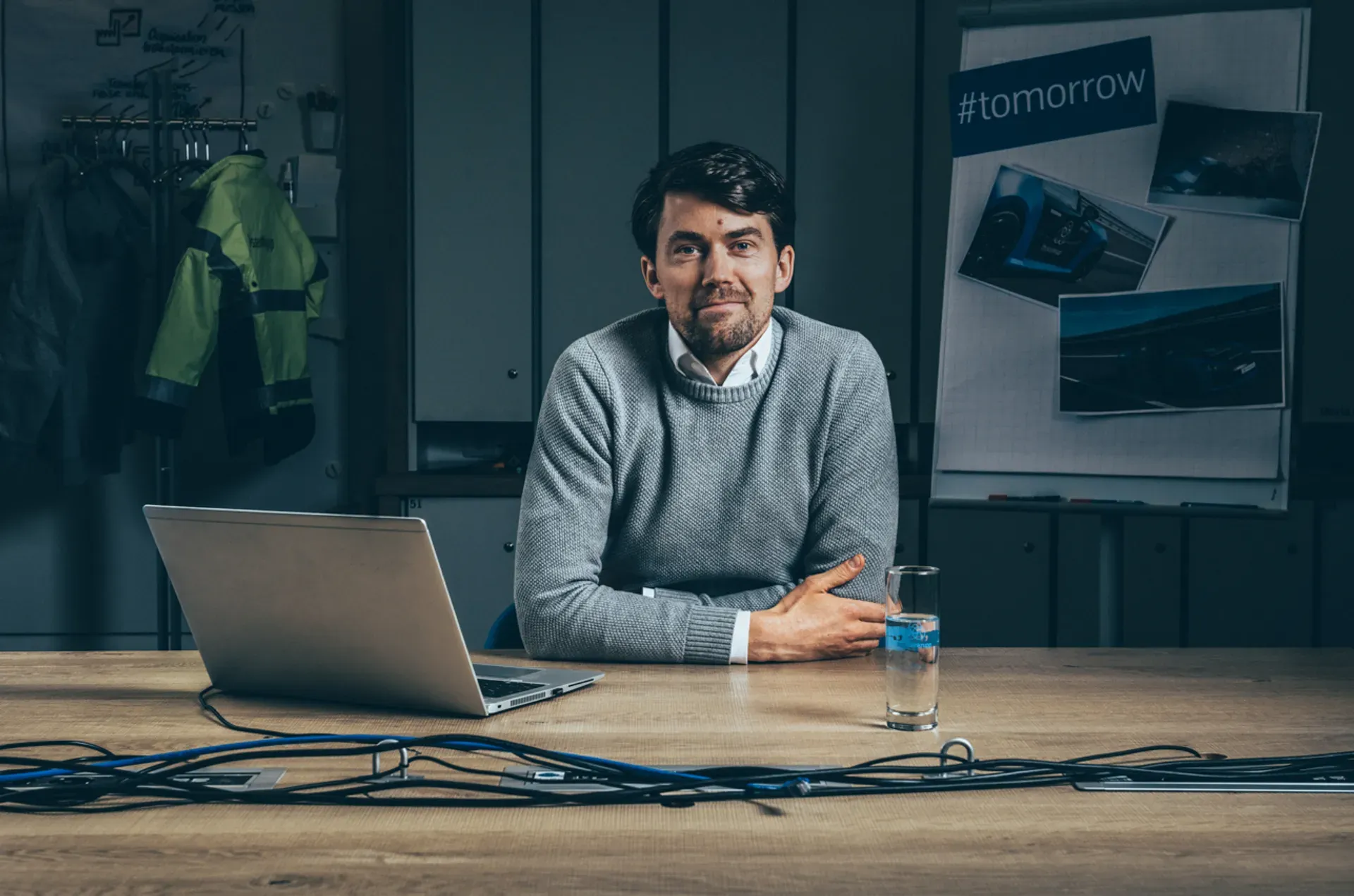 A person is sitting at a table with a laptop in a modern office.