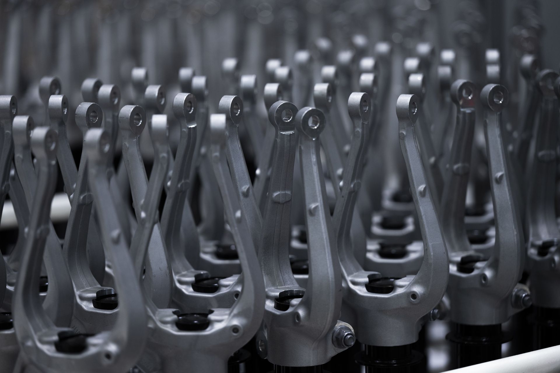Reihen aus metallischen Fahrwerkskomponenten in einer industriellen Produktionsanlage.