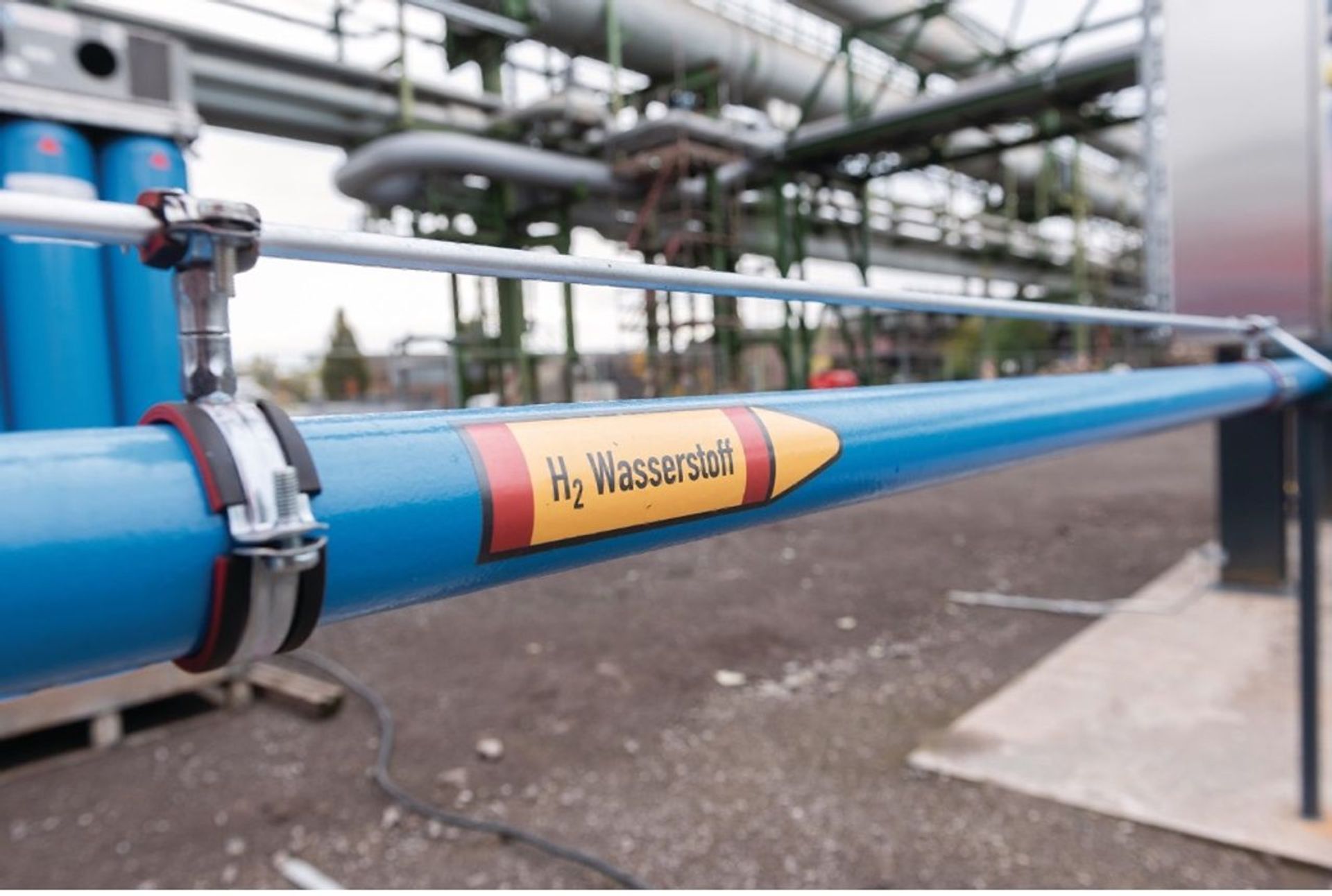 Blaue Rohrleitung mit der Kennzeichnung „H₂ Wasserstoff“ in einer Industrieanlage. Die Leitung steht für den Einsatz von Wasserstoff als klimafreundliche Energiequelle in der zukünftigen Stahlproduktion.
