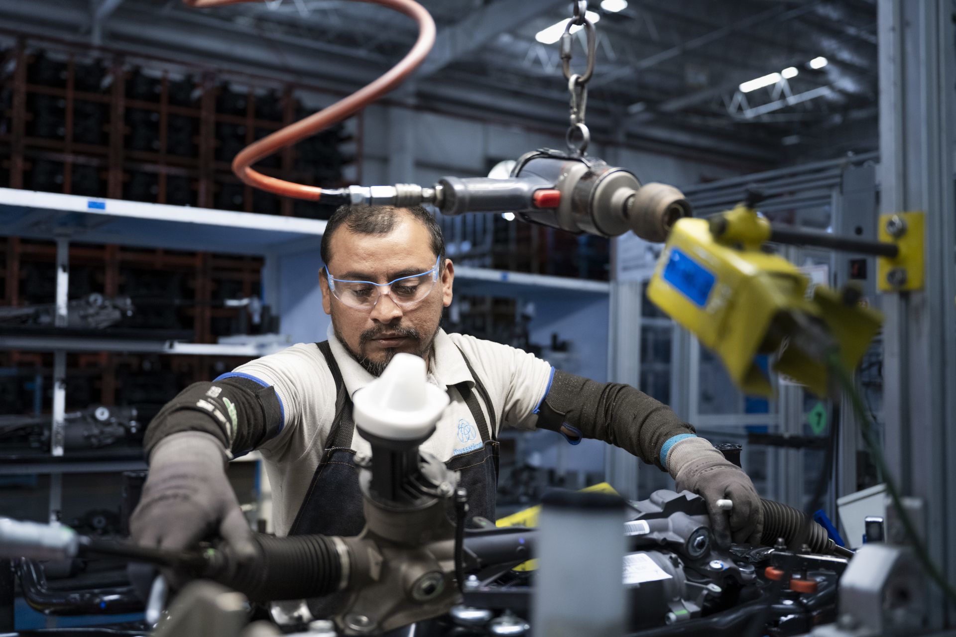 Mitarbeiter von thyssenkrupp montiert ein Industriebauteil in einer modernen Produktionshalle.