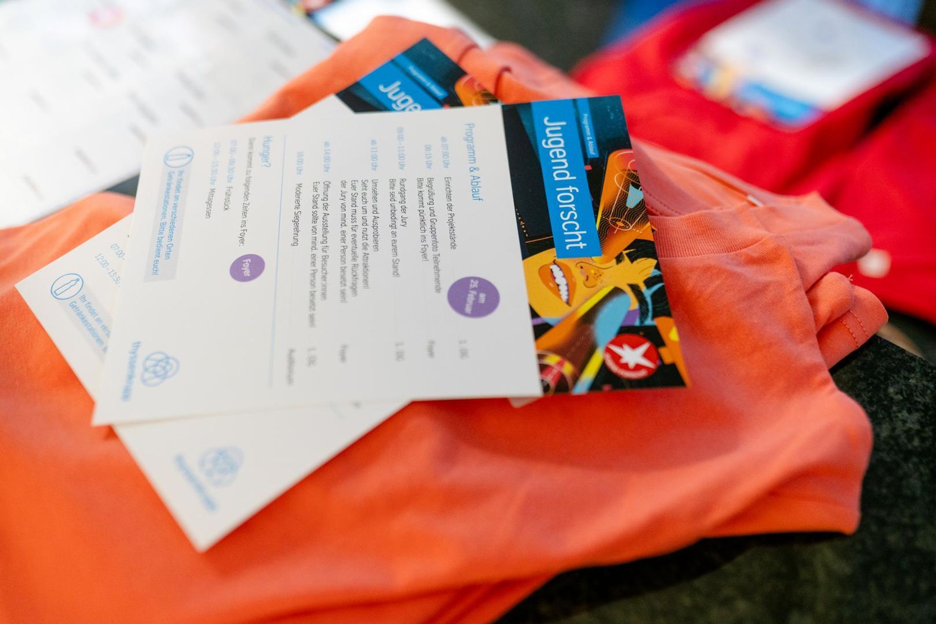 Program flyers and a T-shirt for the thyssenkrupp “Jugend forscht” regional competition.