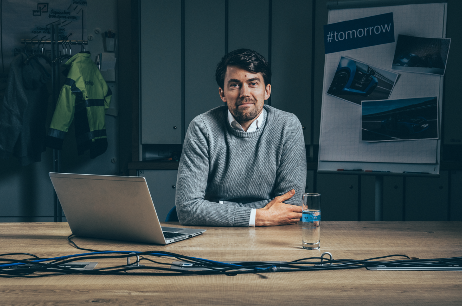 Person sitzt an einem Tisch mit Laptop in einem modernen Büro