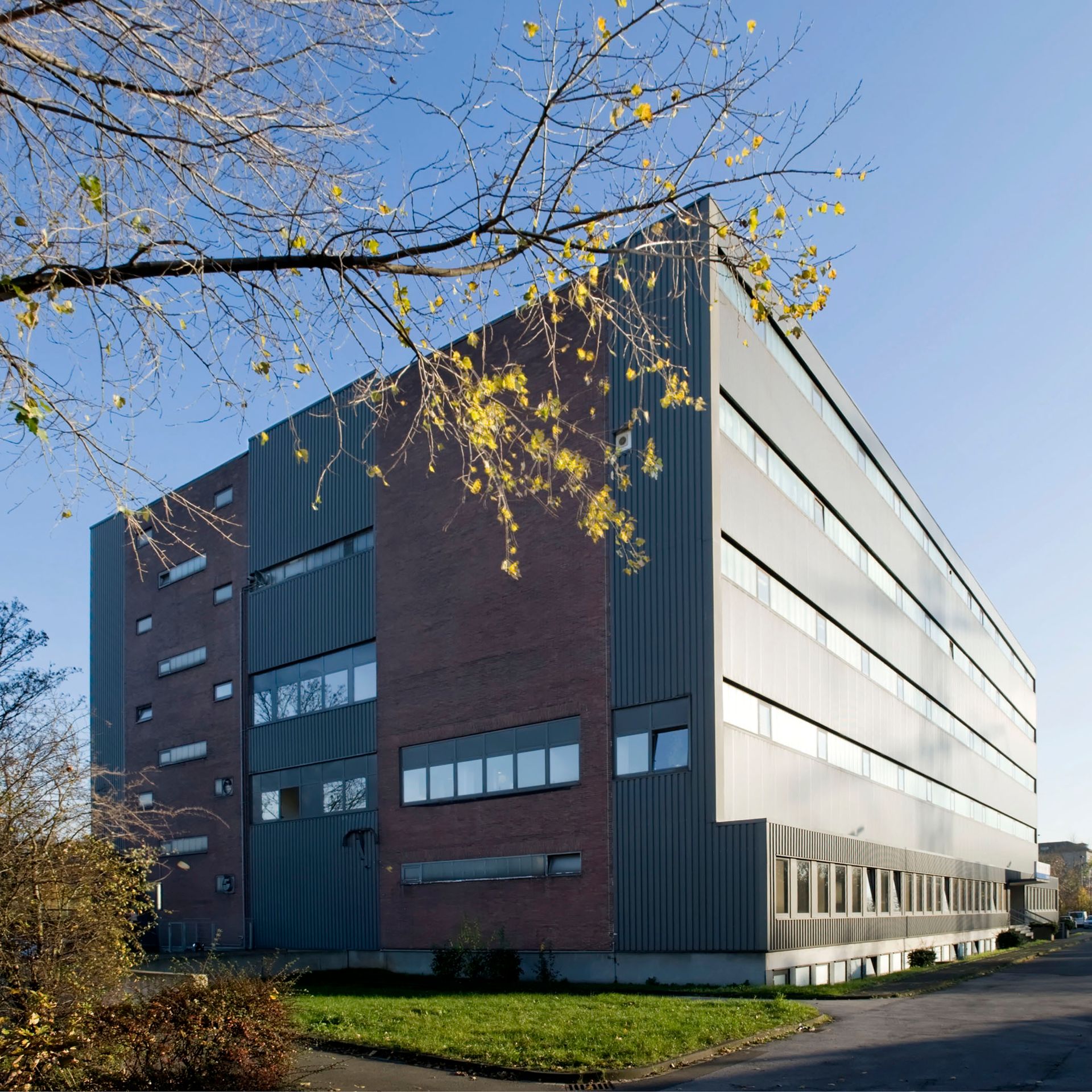 Blick auf das Magazingebäude von thyssenkrupp Corporate Archives in Duisburg, ein moderner Zweckbau mit Backsteinfassade und grauer Metallverkleidung.