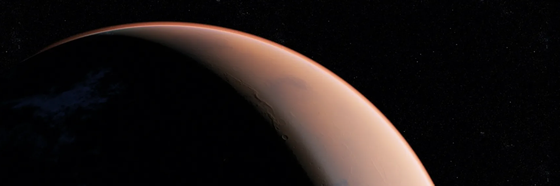 Nahaufnahme des Mars mit orange leuchtender Atmosphäre vor schwarzem Sternenhimmel.
