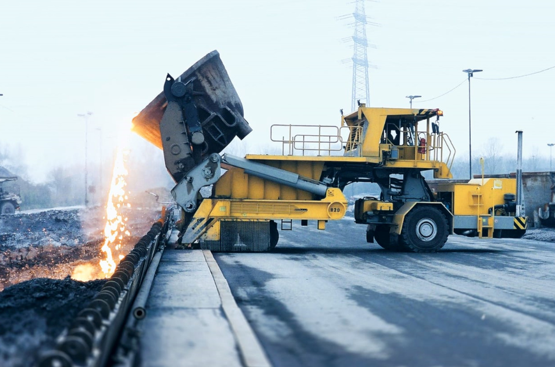 Heavy machinery handling hot metal slag during industrial recycling and steel production processes