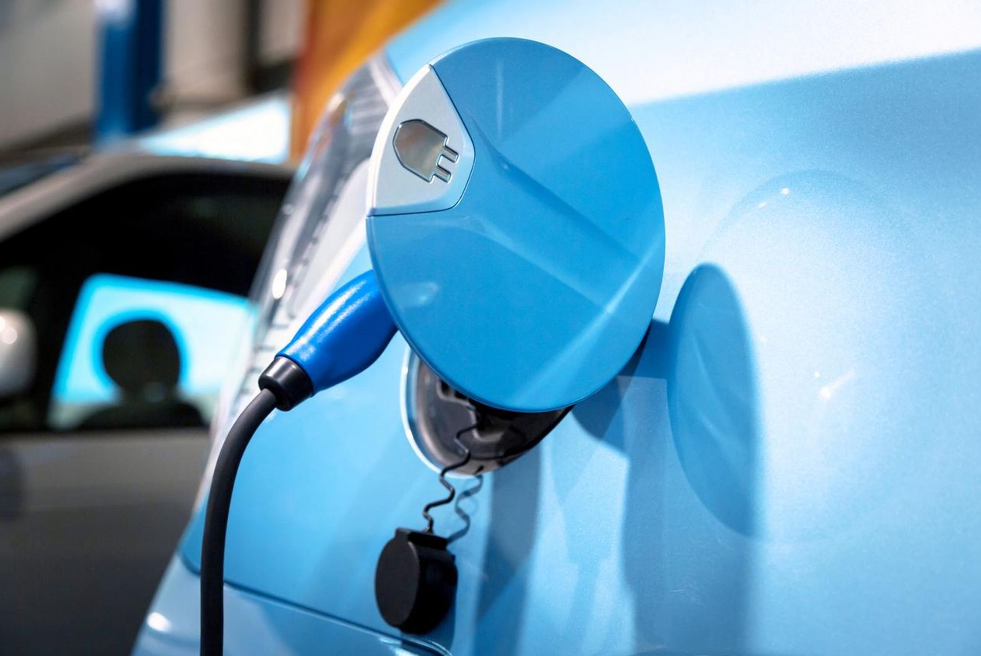 Ausschnitt der Ladebüchse eines Elektro-Autos in blau