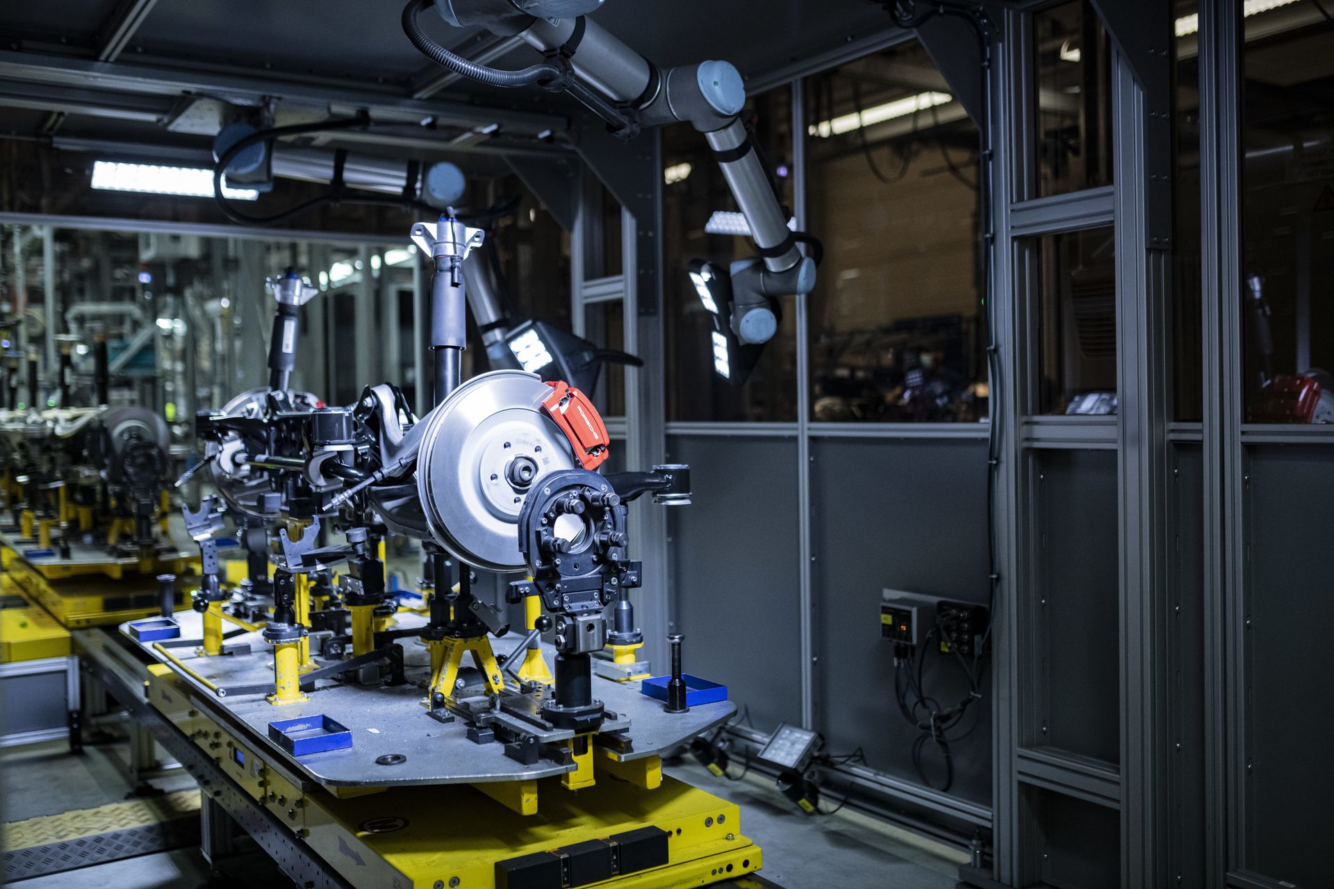 Automatisierte Fertigungsanlage von thyssenkrupp mit einem Fahrwerksmodul und Industrierobotern in einer modernen Produktionsumgebung. Das Bild steht für innovative Fertigungstechnologien und industrielle Automatisierung.