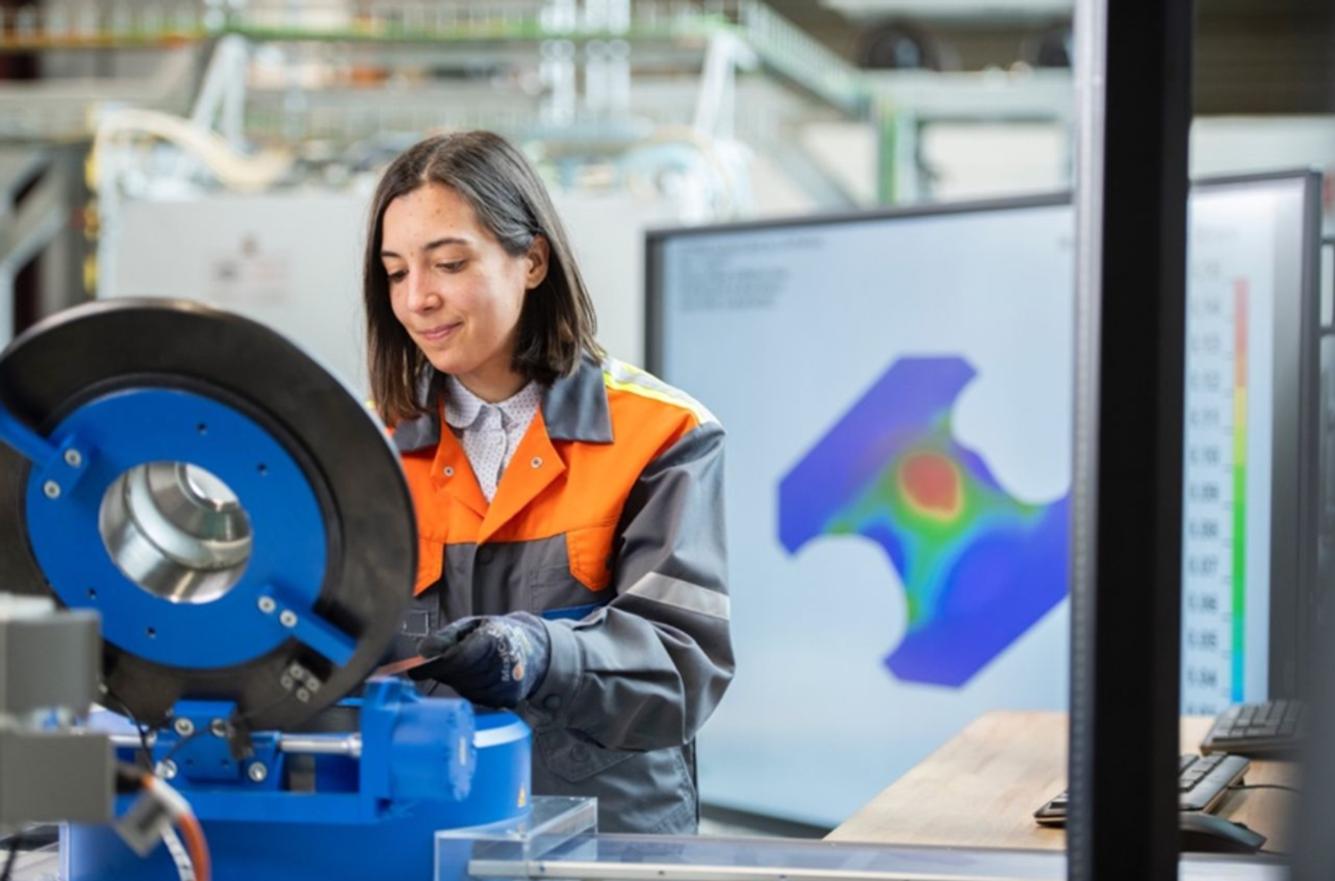 Ingenieurin arbeitet an einer Maschine im Labor und nutzt digitale Simulationen zur Optimierung von Weißblech und Verpackungsstahl.