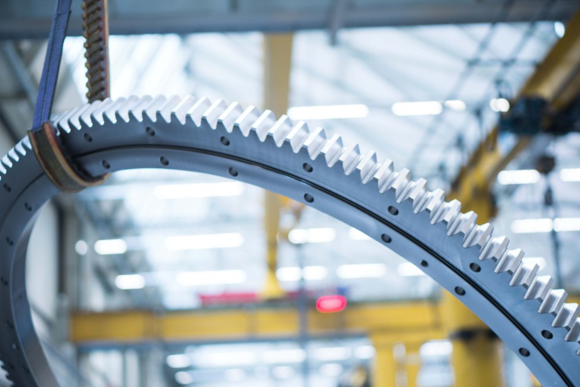 Large-diameter antifriction bearings with gearing are manufactured in a production hall for use in wind turbines.