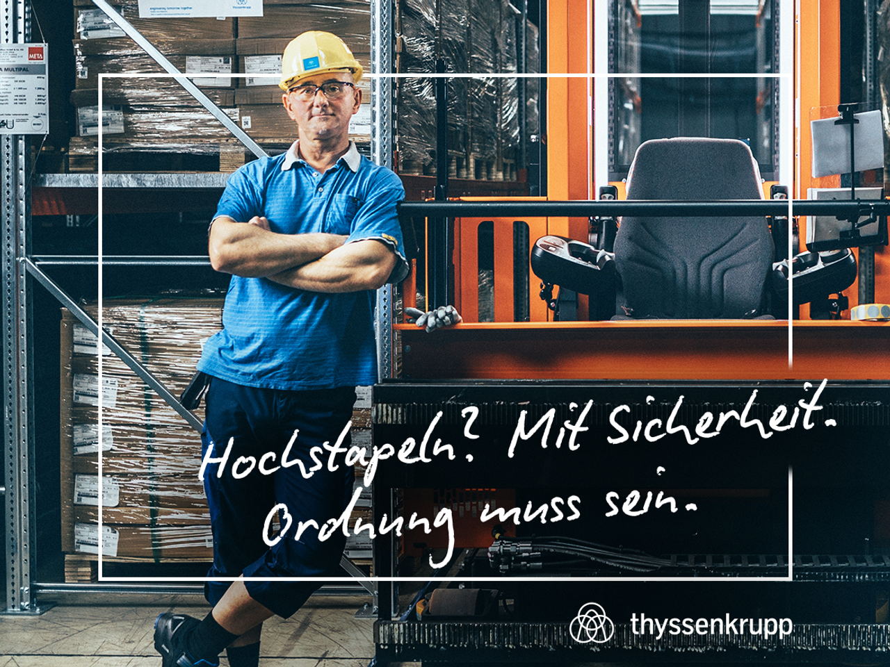 Mann steht neben Gabelstapler