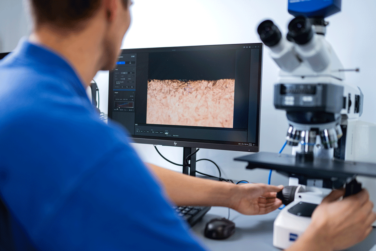 Man photographed from behind using a microscope