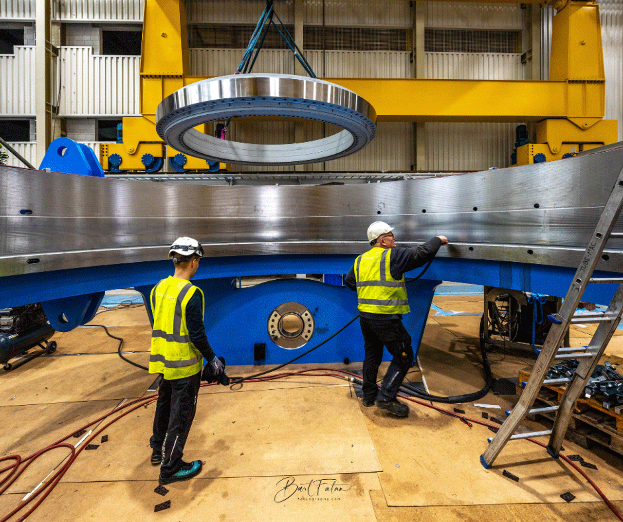Two men working on a slewing bearing