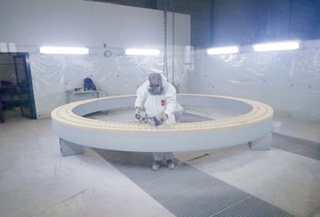 Person in protective gear painting a slewing bearing