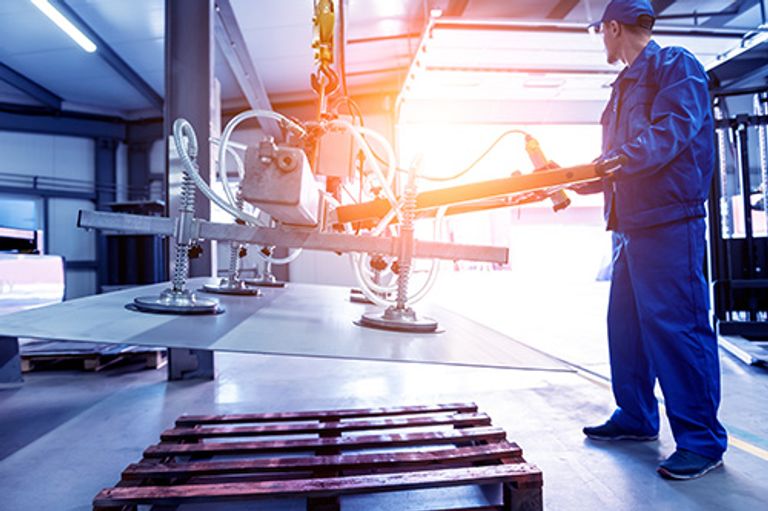 thyssenkrupp medewerker die grote platen in metaal transporteert met zuignappen