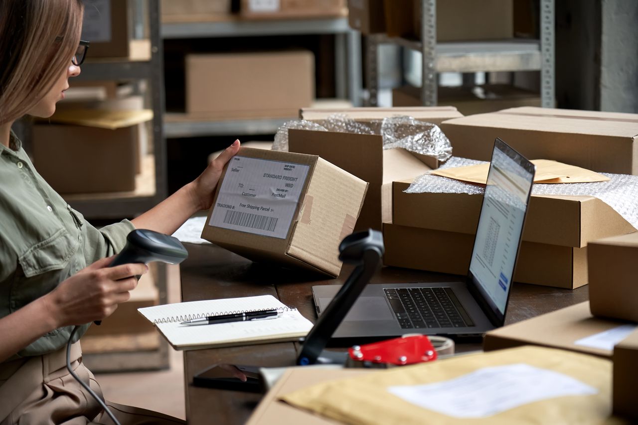 person in warehouse environment working on ecommerce fulfillment by scanning in orders with device