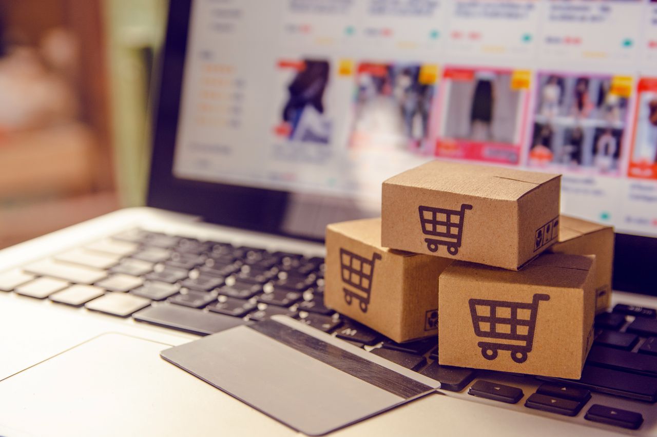 3PL partner in E-commerce fulfillment services showing a customer putting boxes in cart online with little boxes on keyboard that have cart icons on them