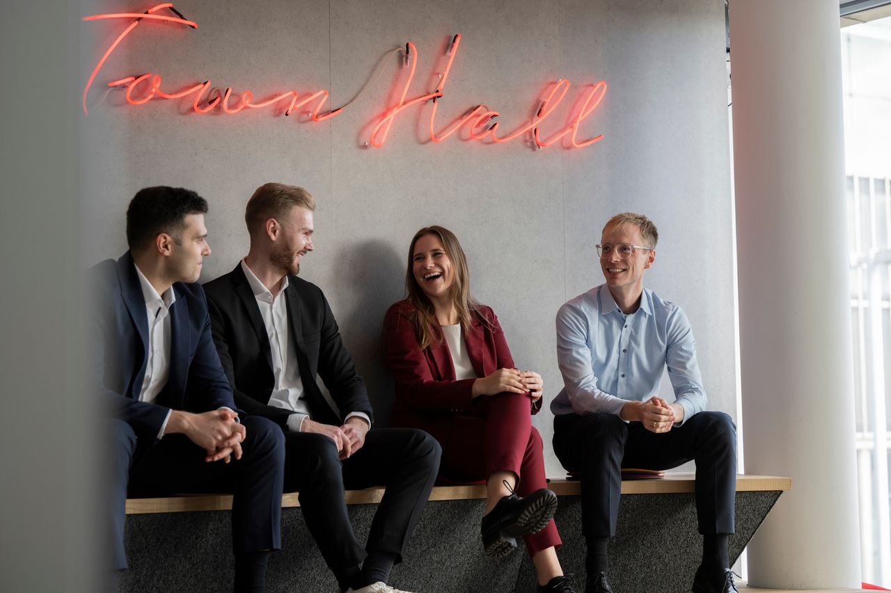Kutlu Öztas, Henrik Fricke, Rebecca Delbeck und Simon Goldbeck-Fabian sitzen als Team zusammen und unterhalten sich. 