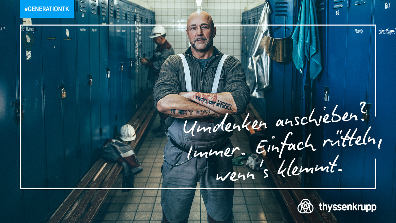 Jürgen Schaab steht in einer Umkleide, er hat seine Arme verschränkt, auf denen "Man of Steel" tätowiert steht. Schrift im Vordergrund: Umdenken anschieben? Immer. Einfach rütteln, wenn's klemmt.