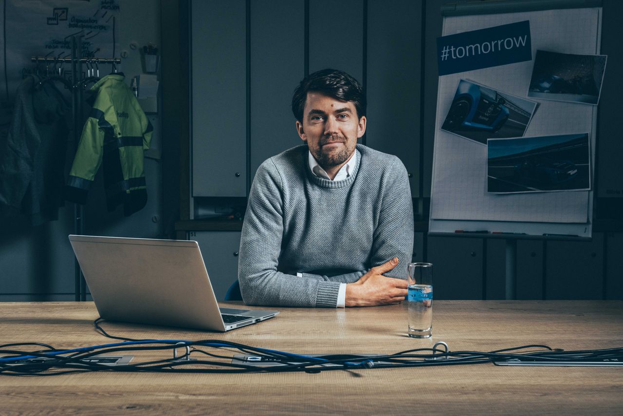 Daniel Thiele sitzt auf einer Plattform vor einem Aufbau mit Bildschirm, Lenkrand und Sitz